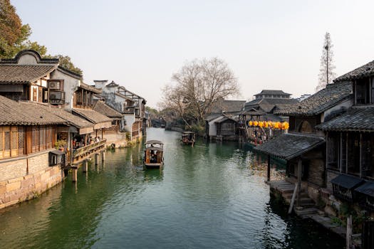 Picturesque canal scene in Wuzhen, China with traditional buildings and boats at sunset.