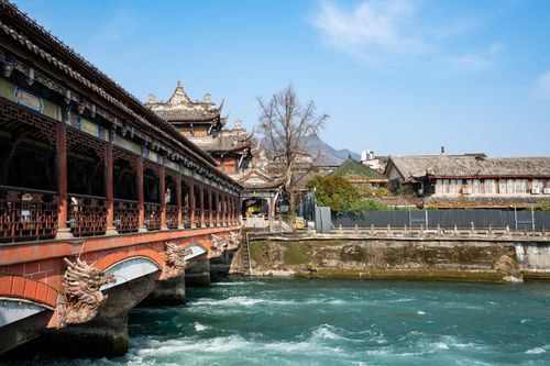 Free Scenic view of an ancient Chinese bridge with dragon carvings and architectural details over a river in bright daylight. Stock Photo