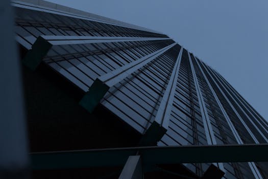 在低角度下拍摄的黑暗天空与未来主义摩天大楼，营造出喜怒无常的城市场景