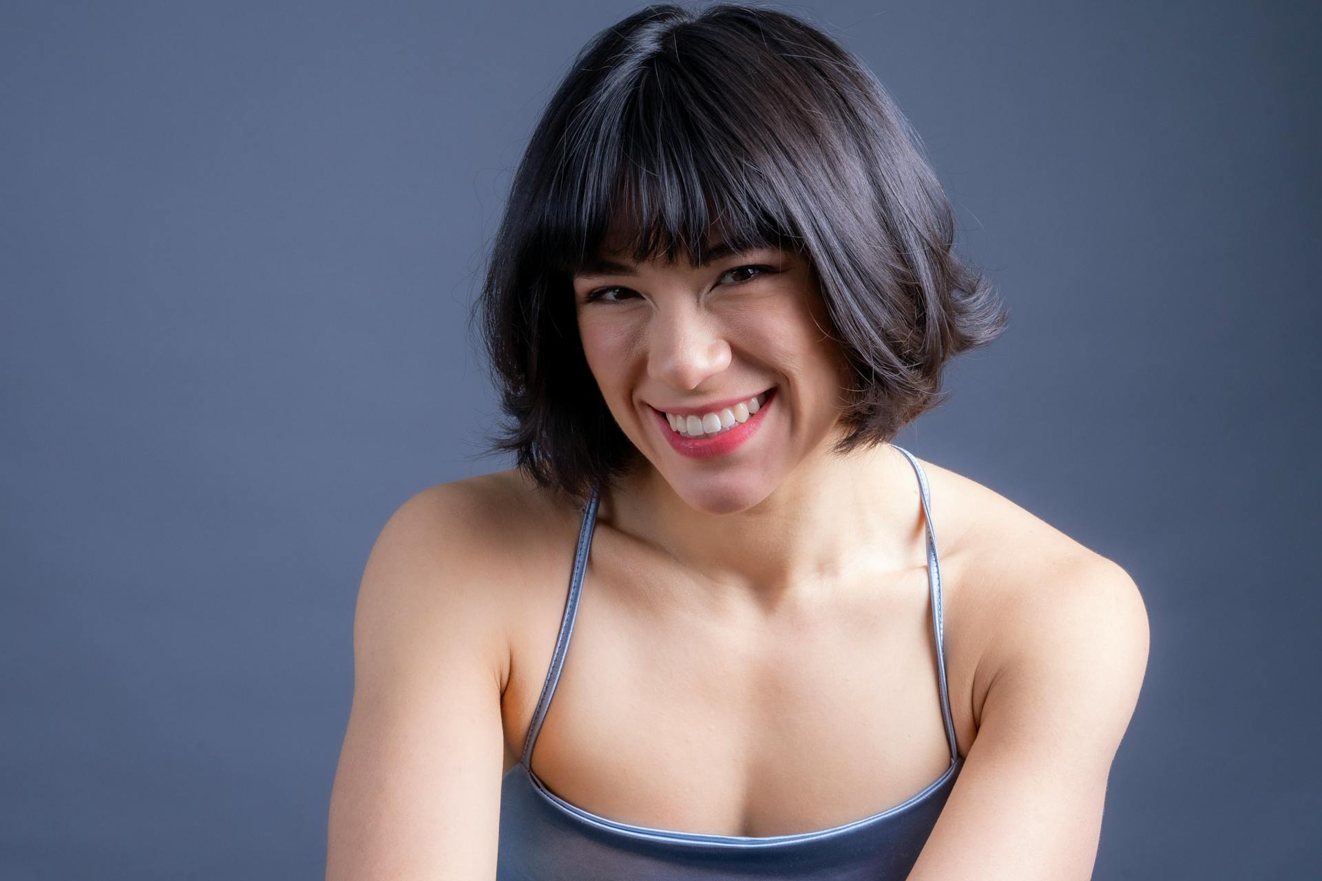 A cheerful woman smiling in a studio. Perfect for lifestyle and portrait themes.