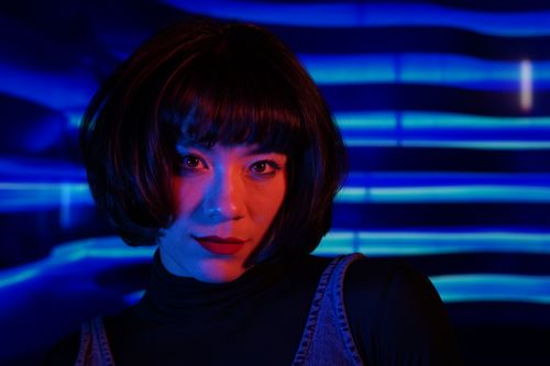 Free Stylish woman with bold makeup in vibrant neon lighting. Stock Photo