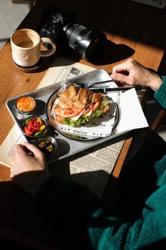 Tasty croissant sandwich with fresh vegetables served at a cozy Istanbul cafe.