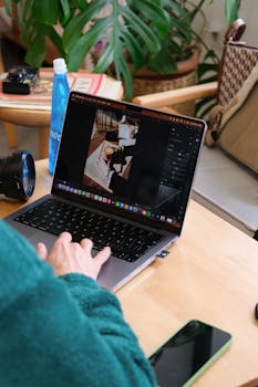 Person editing photos on a laptop in a cozy indoor setting in Istanbul, Türkiye.