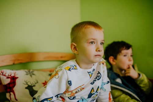 Free Two young boys watching intently in a cozy indoor setting with playful decor. Stock Photo