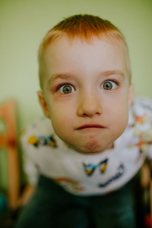 Close-up portrait of a curious red-haired child