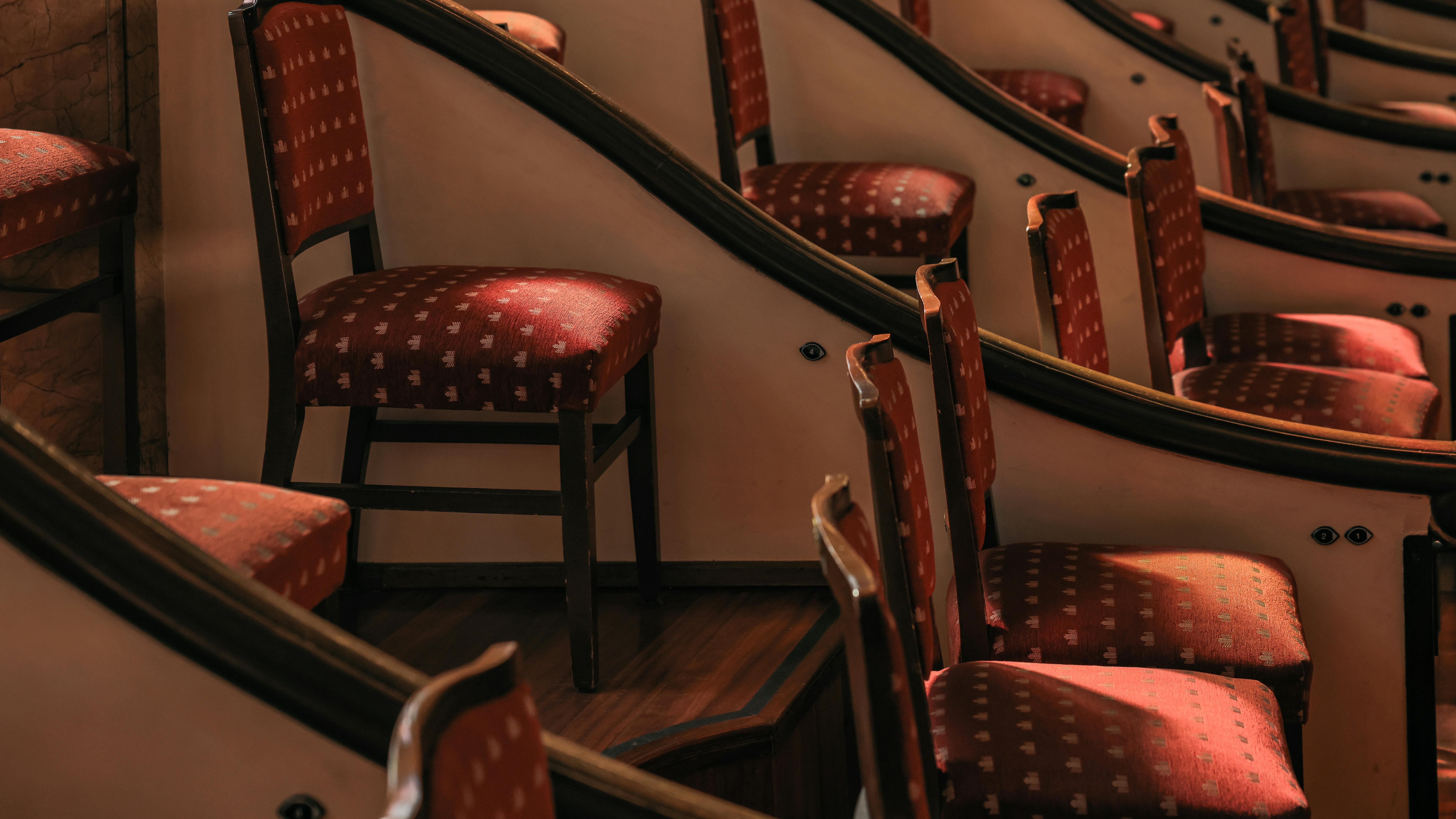 Free Curved rows of elegant red theater seats in a sunlit Barcelona auditorium. Stock Photo