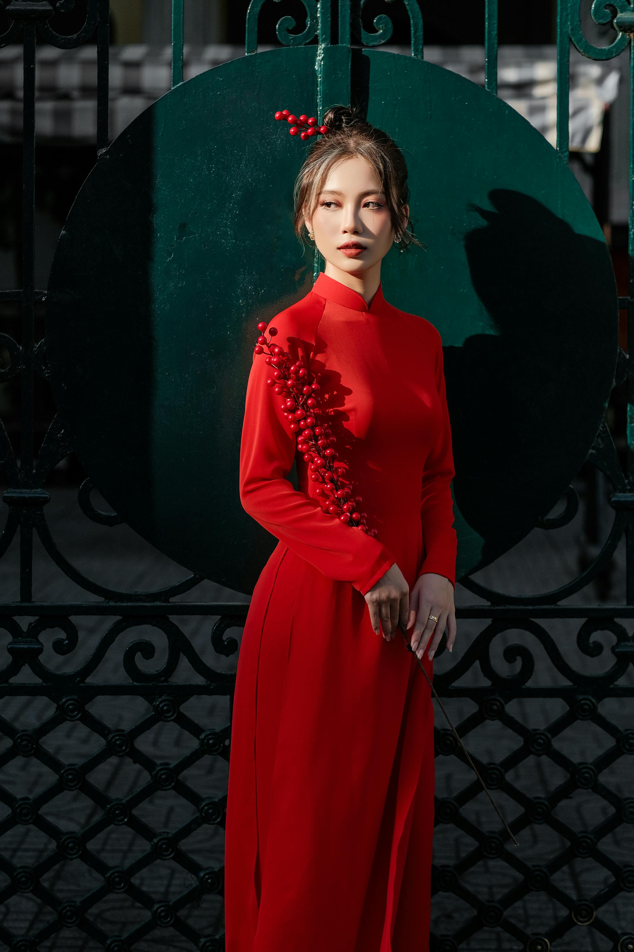 Elegant woman in red dress posing outdoors in Ho Chi Minh City, Vietnam.