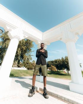 Elegant outdoor portrait of a man under white arches in Doha, Qatar.