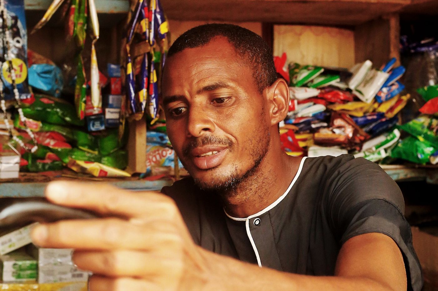 Un homme range des produits dans une boutique à Abuja