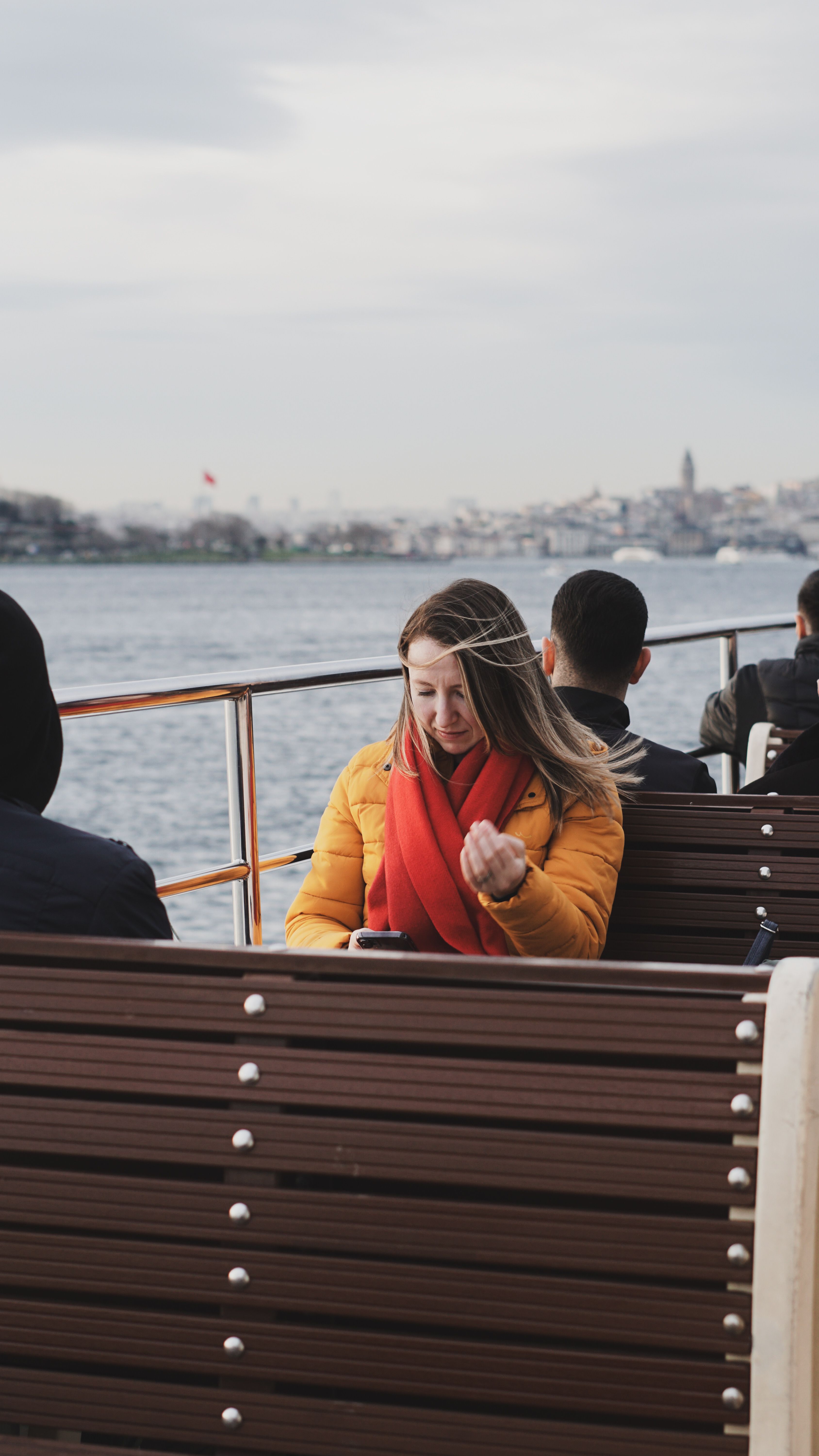 Young Woman Relaxing on Ferry with City View · Free Stock Photo