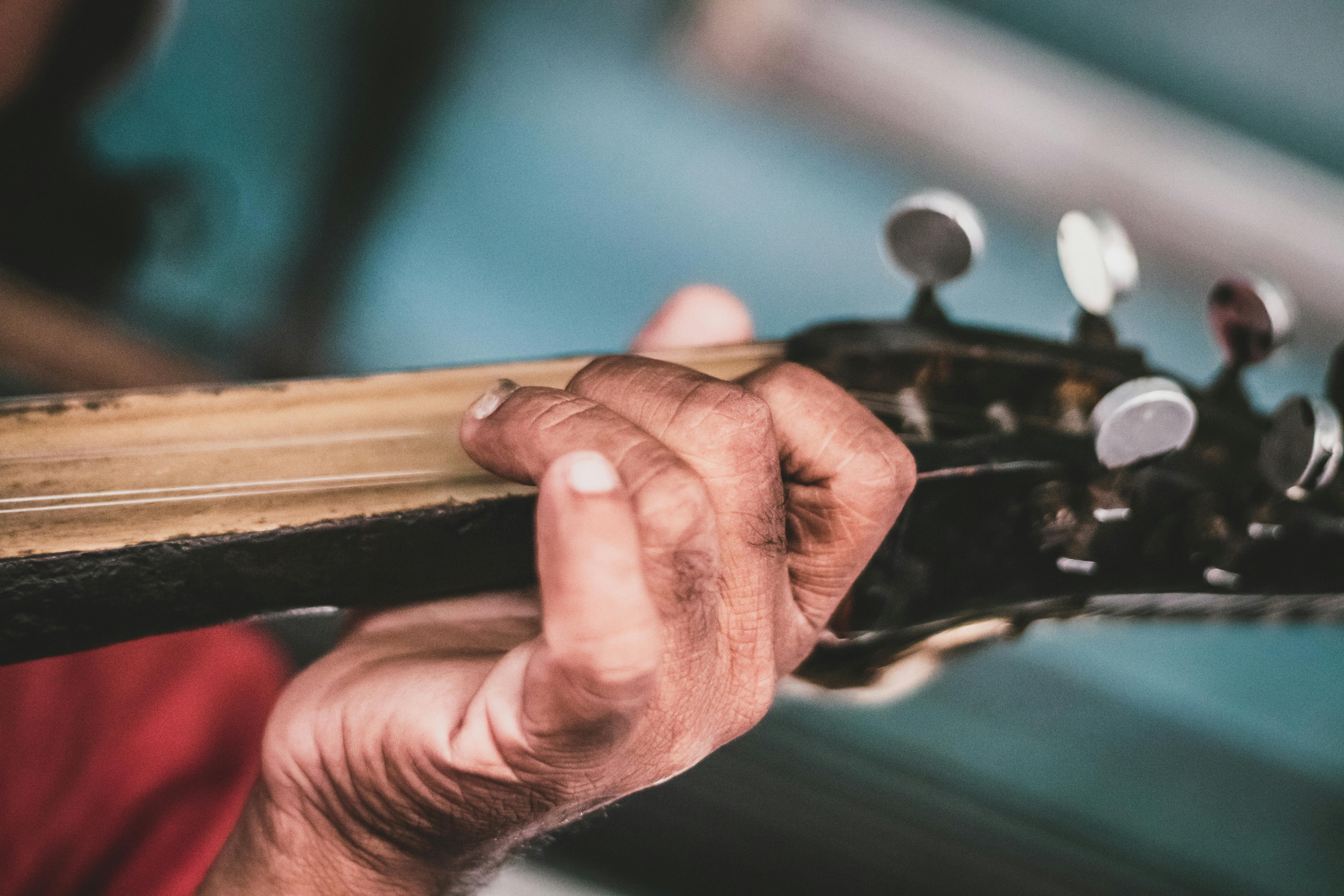 Close Up Photography Of Person Playing Guitar Free Stock Photo