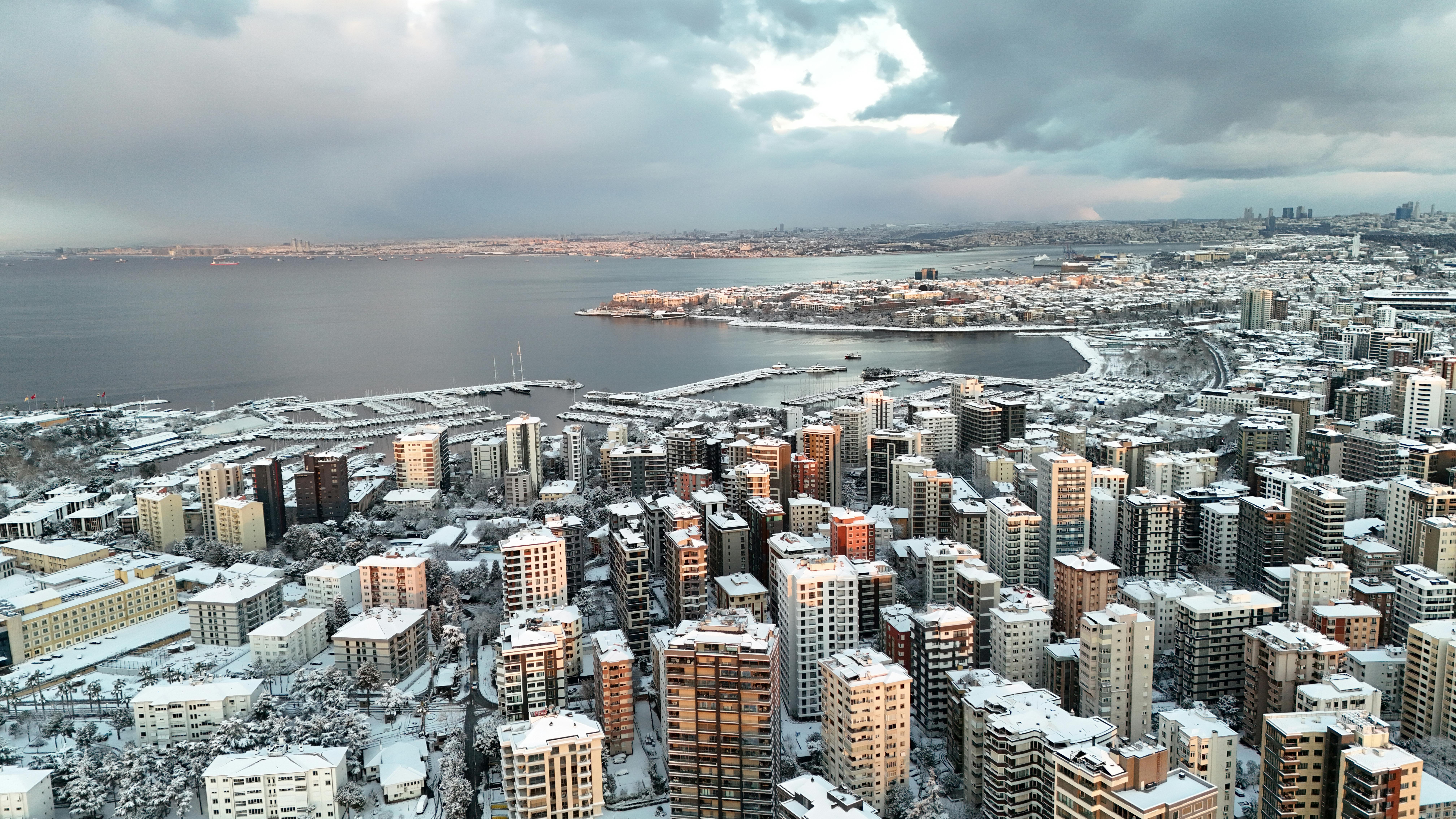 Aerial view of Istanbul with snow-covered buildings and the Bosphorus in winter.