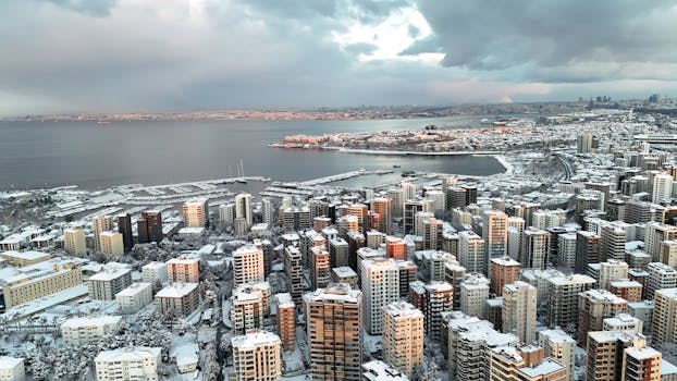 Aerial view of Istanbul with snow-covered buildings and the Bosphorus in winter.