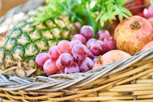 Free Grapes, Apple, and Pineapple on Brown Wicker Basket Stock Photo