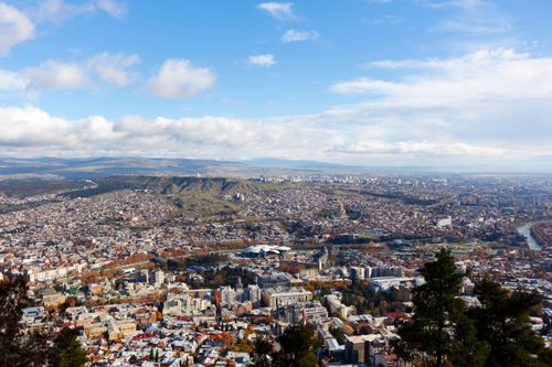 Free A sweeping aerial view of Tbilisi, Georgia showcasing the city's expansive architecture and lush landscape. Stock Photo