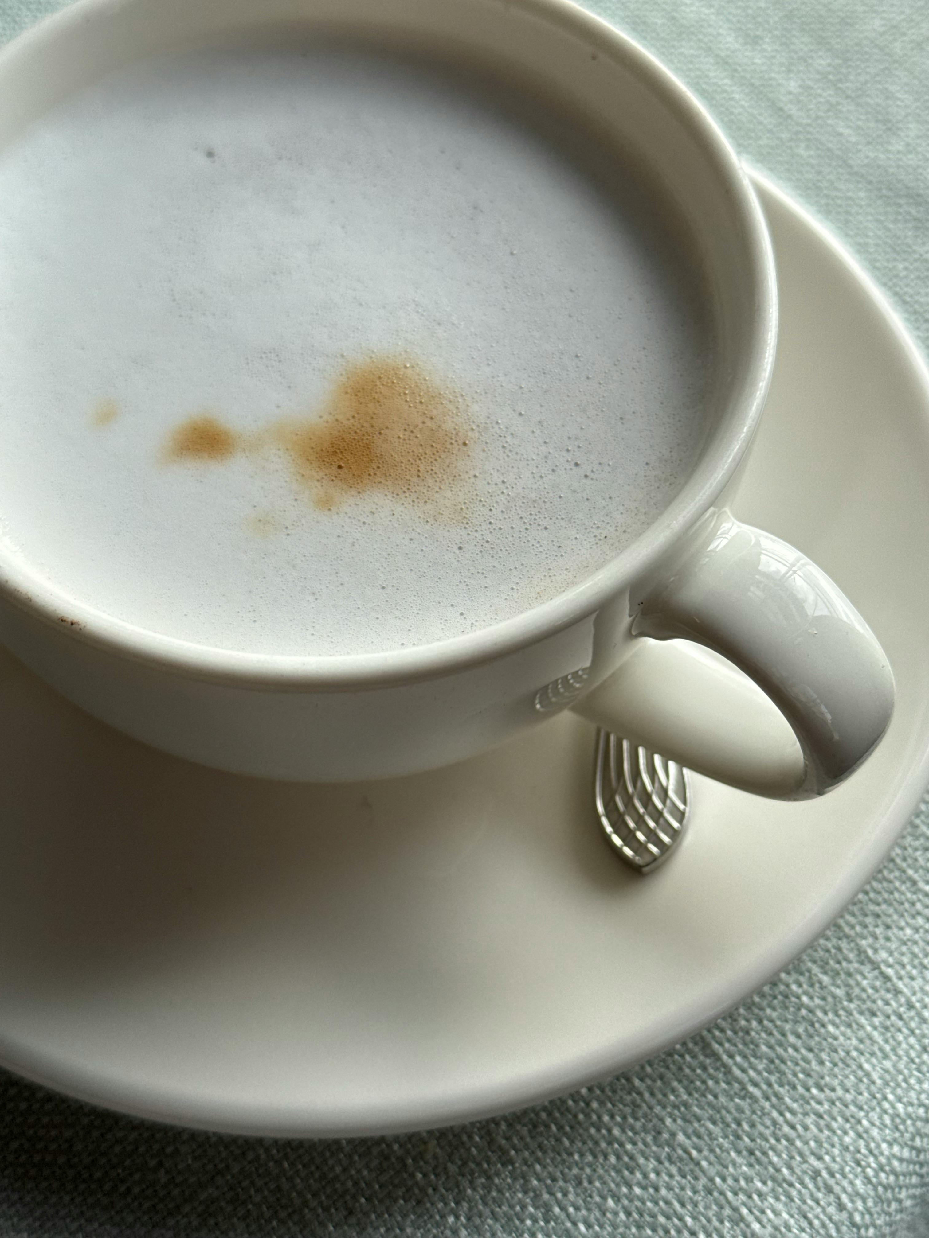 Close-up of a coffee cup with foam art, perfect for café themes.