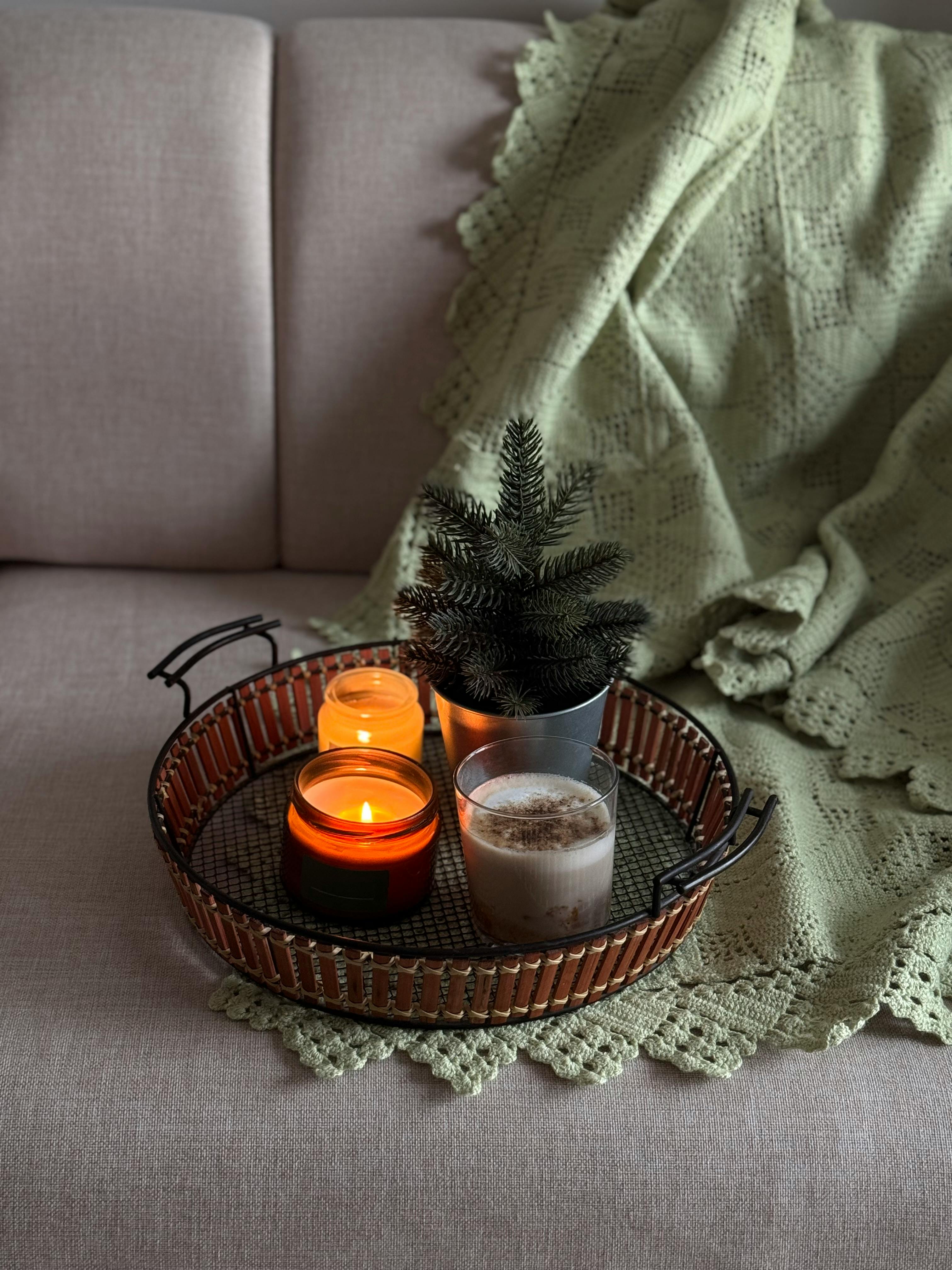 Warm, cozy scene with candles and blanket, ideal for relaxation or winter decor.