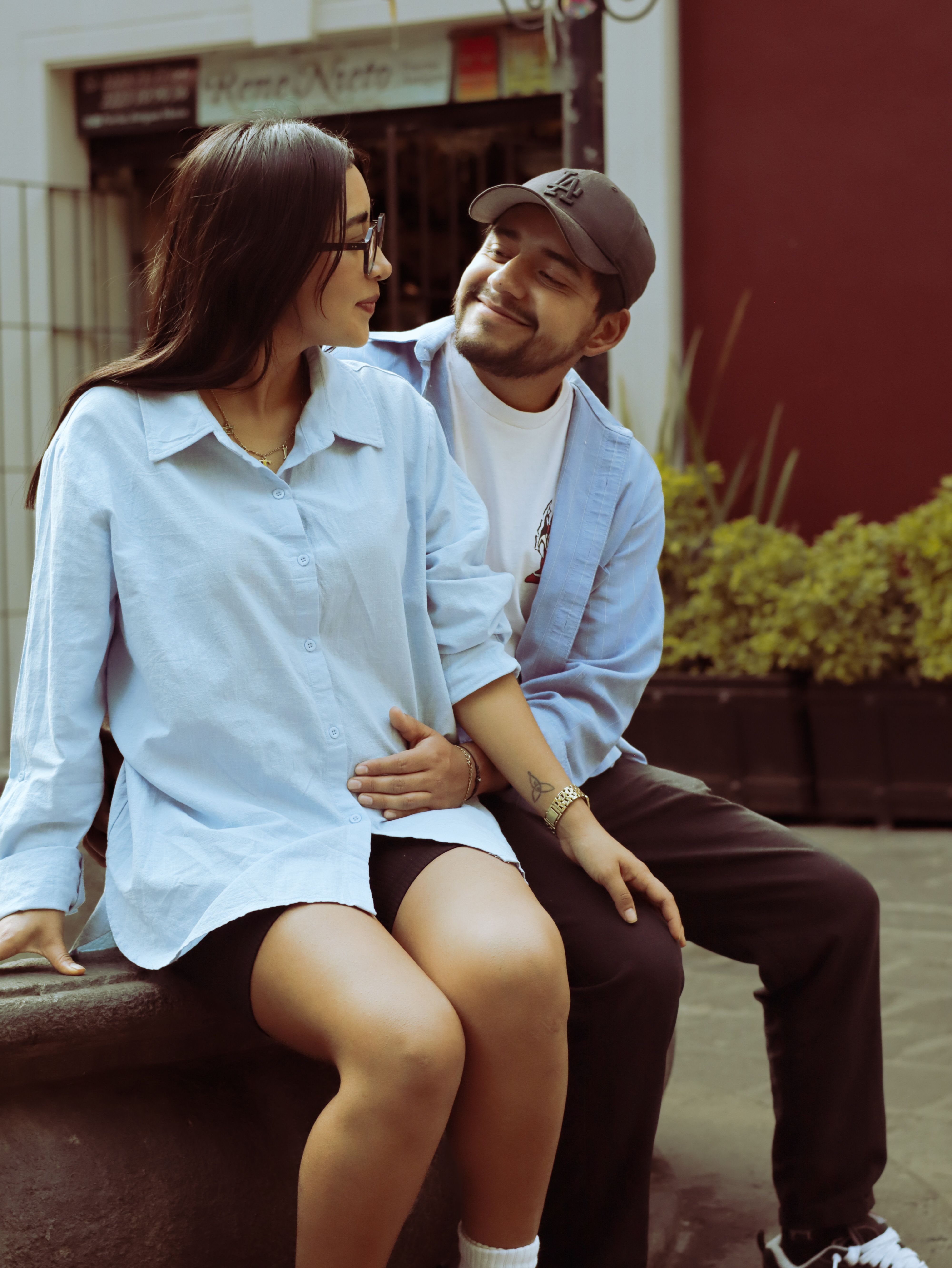 A young couple sitting together, enjoying a calm moment outdoors in an urban setting.