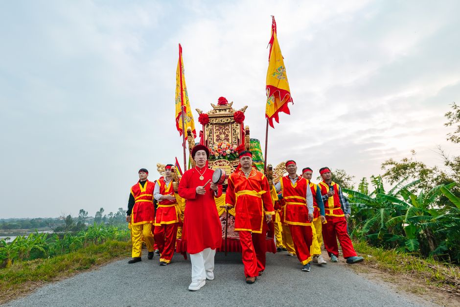 Colorful traditional festival procession with people in vibrant costumes and decorative flags.