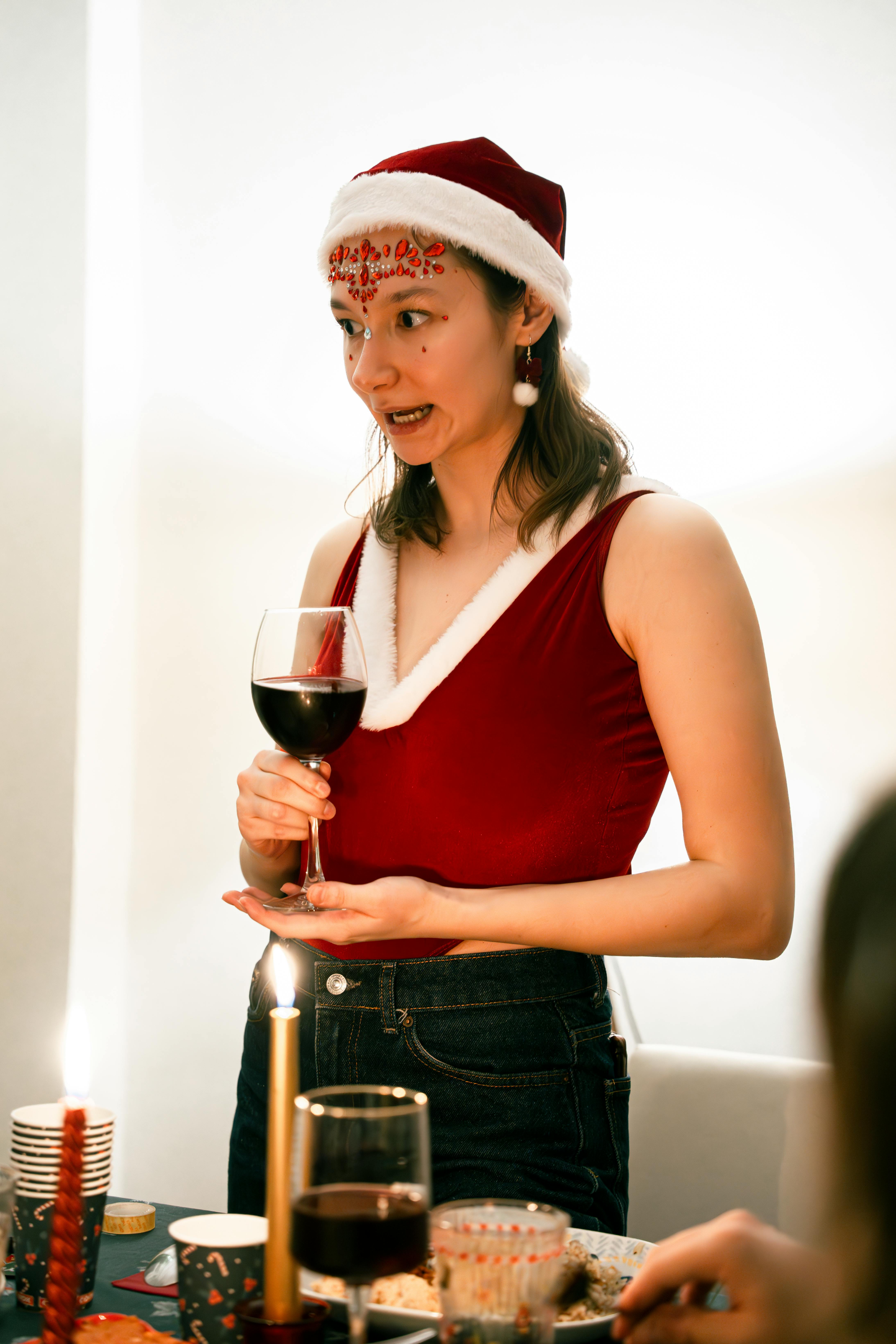 festive gathering with woman in santa hat holding wine