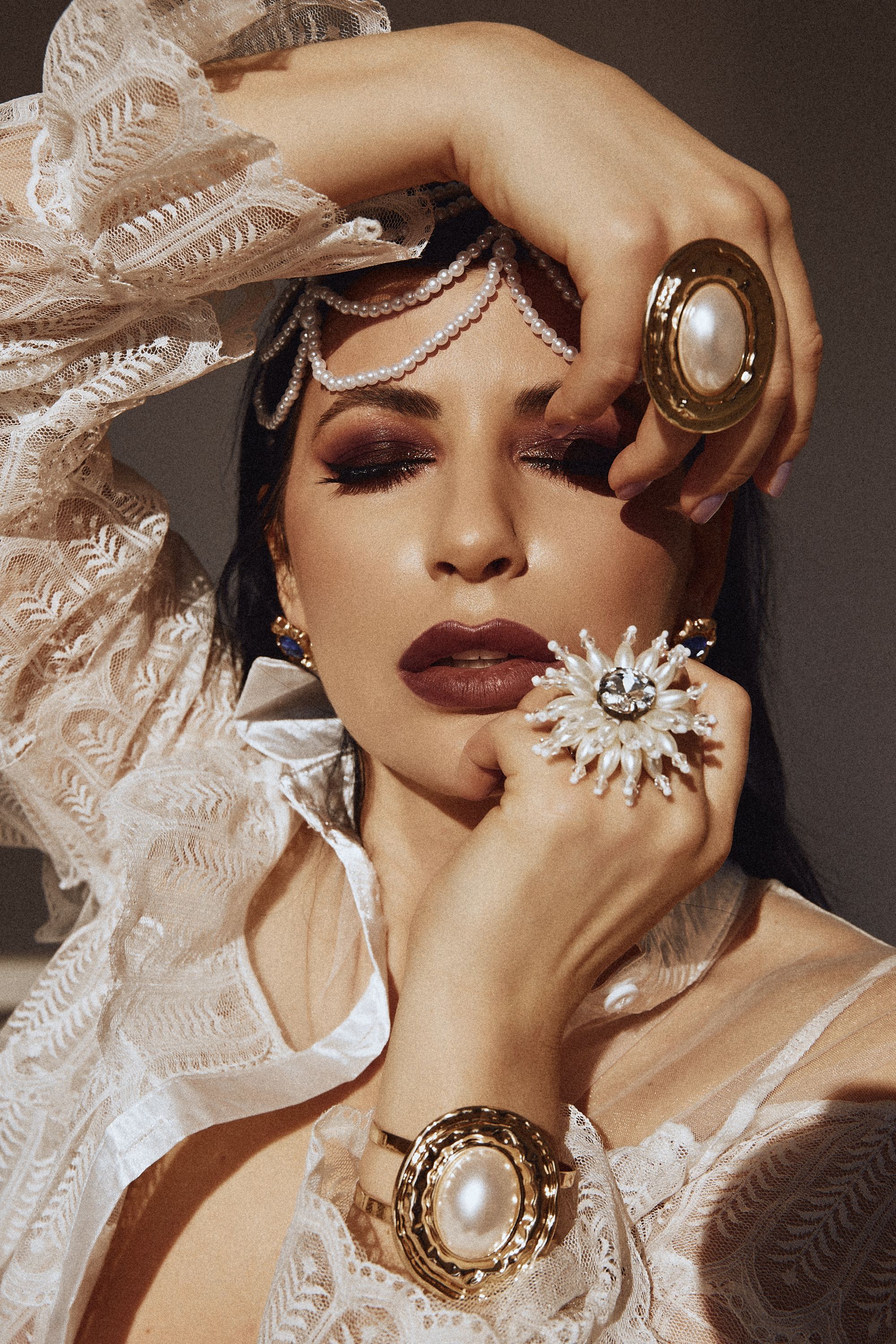 Portrait of a woman in vintage lace and bold jewelry, exuding elegance and glamour.