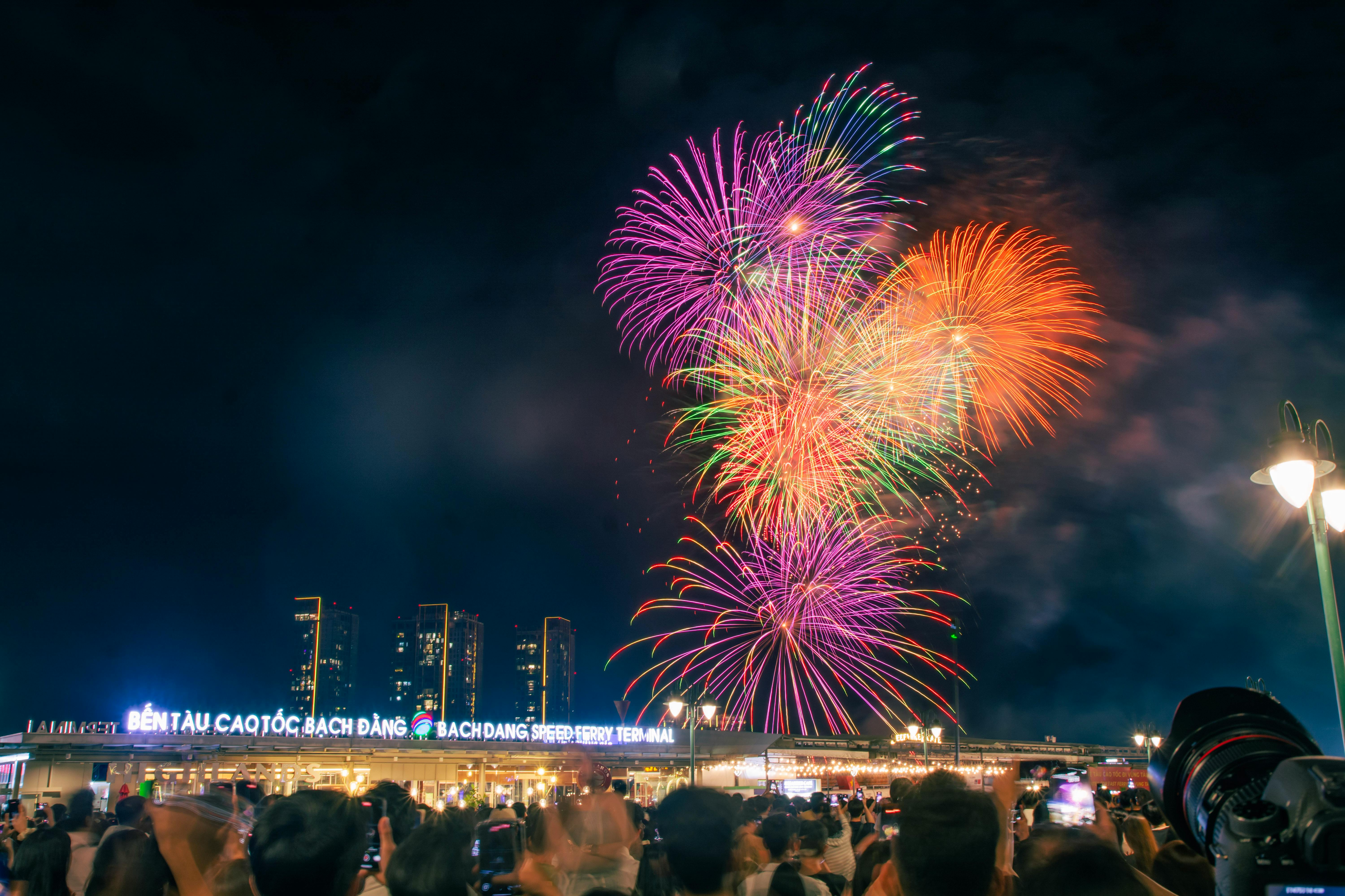 Crowd watches colorful fireworks burst in the night sky over Ho Chi Minh City.