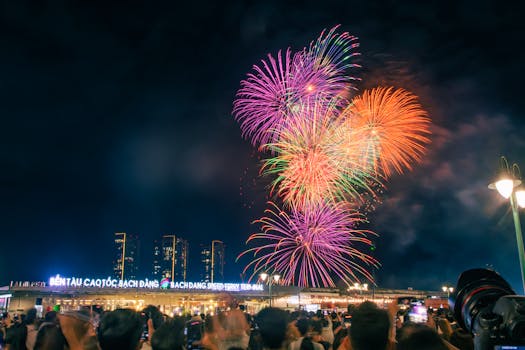 Crowd watches colorful fireworks burst in the night sky over Ho Chi Minh City.