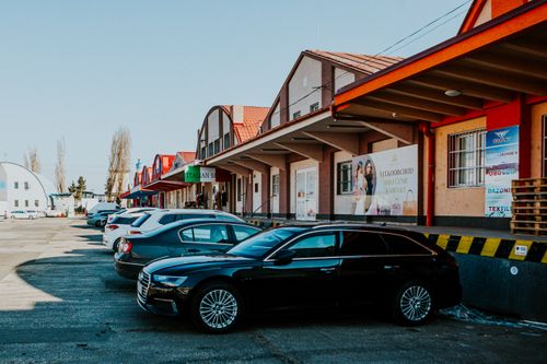 Free Parking lot with modern cars outside a commercial building with various shops. Stock Photo