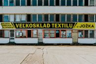 Old textile warehouse with a weathered facade and signage in an urban location.