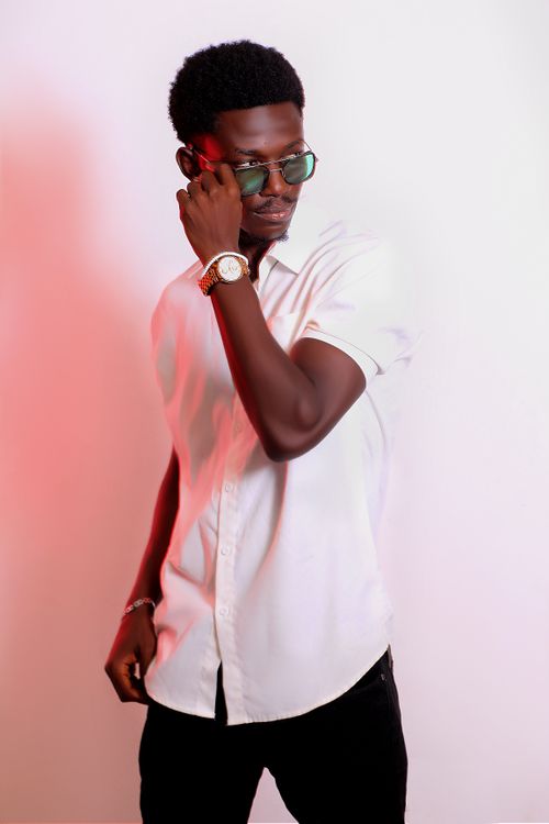 Free Fashion-forward young man in a white shirt with sunglasses and a wristwatch posing confidently. Stock Photo