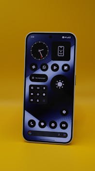 Stylish smartphone with apps on vibrant yellow background, showcasing modern technology.