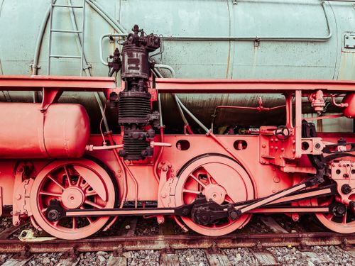 Free Detailed close-up of a vintage steam locomotive's wheels and mechanical parts. Industrial and historical charm. Stock Photo