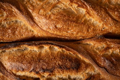 Free Detailed texture of golden crusted artisan baguettes fresh from the oven. Stock Photo