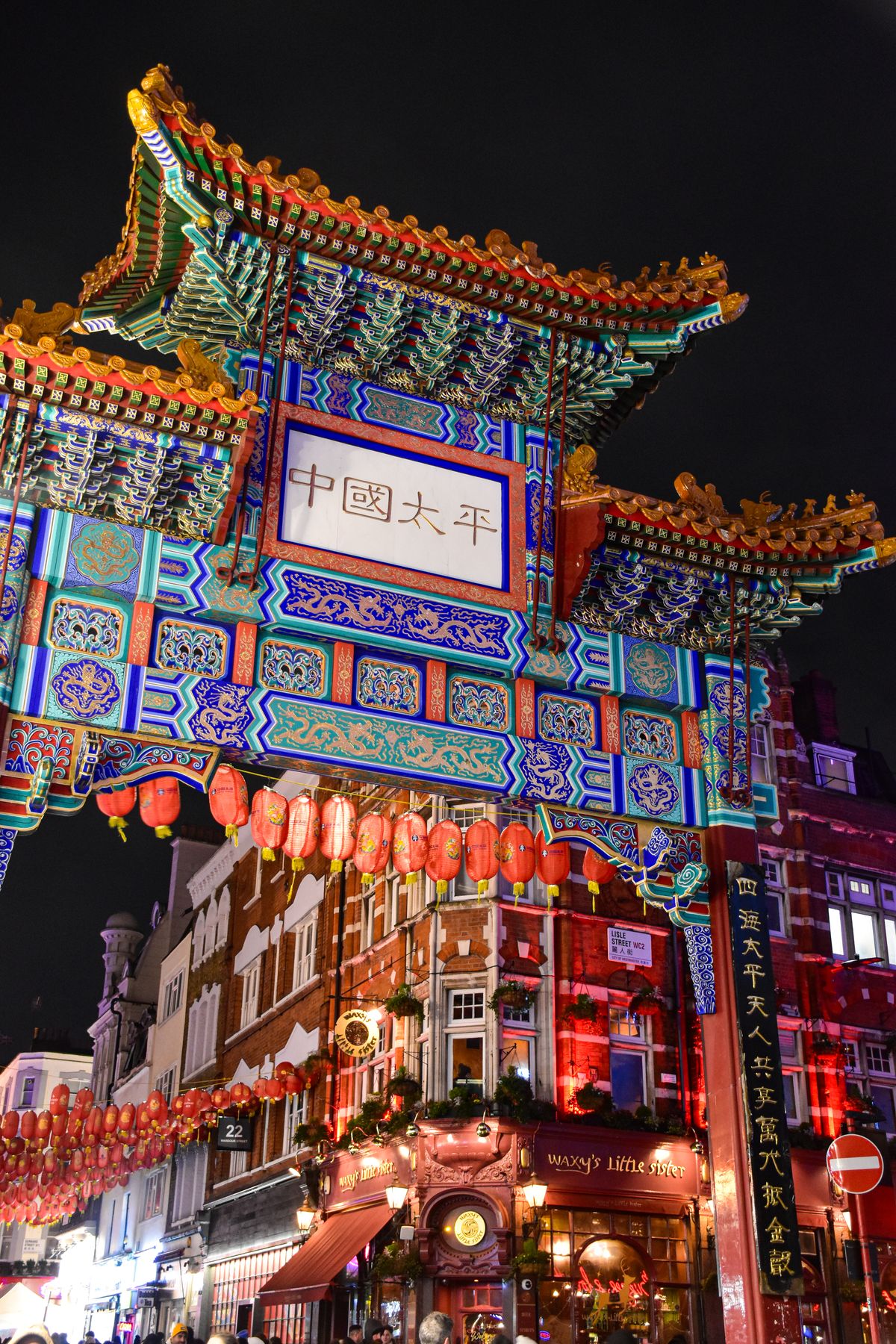 London's Chinatown gateway lit up at night with red lanterns and neon signs