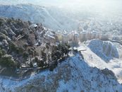 Aerial view of Çankırı, Türkiye, covered in snow, showcasing urban and natural landscapes.
