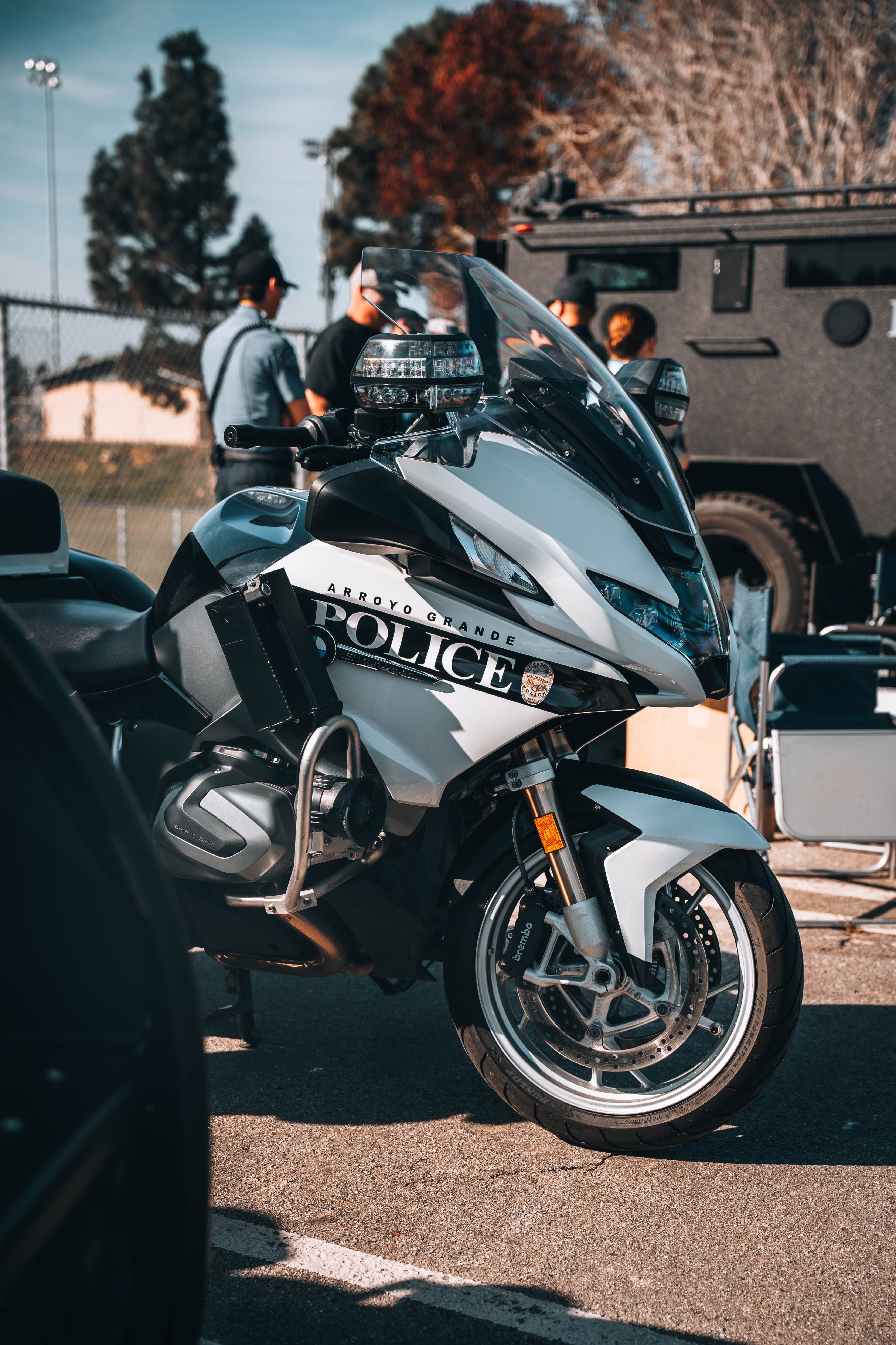 A police motorcycle displayed at an outdoor event with people in the background.