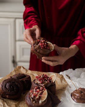 Chocolate muffins topped with pomegranate seeds and citrus slices, styled indoors.