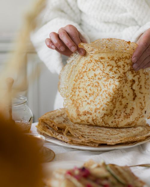 Free A person prepares homemade pancakes in a cozy kitchen setting, emphasizing rustic charm. Stock Photo