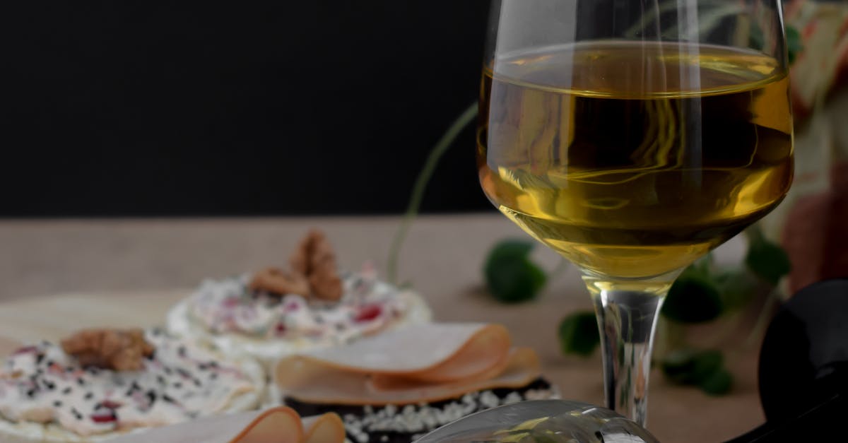 Photo by Bade Saba A stylish display of gourmet snacks paired with a glass of white wine in a cozy setting.