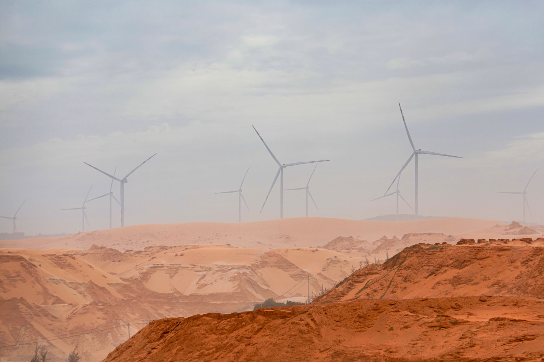 Wind turbines standing tall in the Bình Thuận desert, showcasing renewable energy.