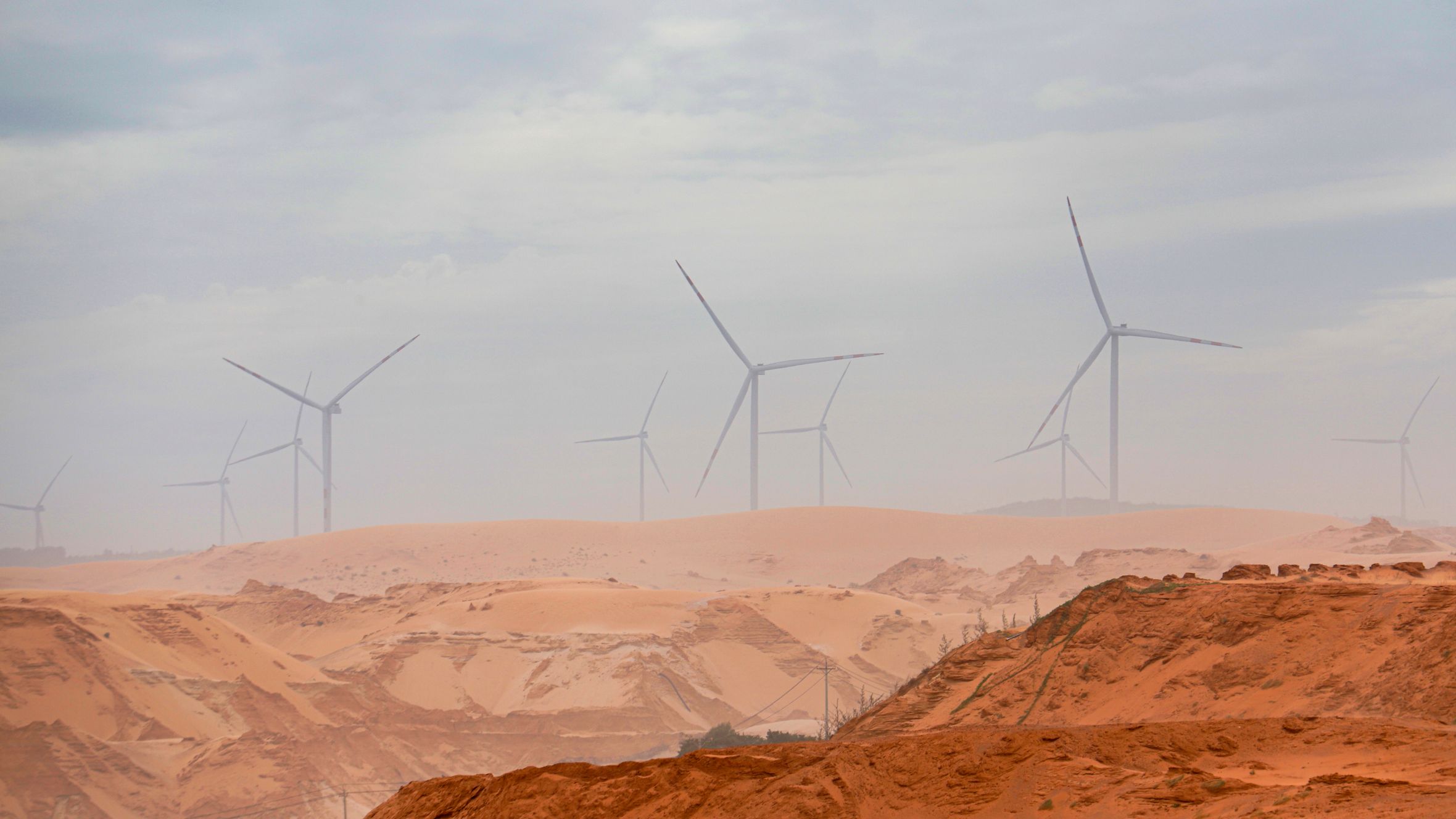 Wind turbines standing tall in the Bình Thuận desert, showcasing renewable energy.