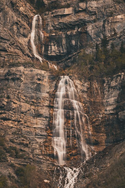 Free Scenic waterfall cascading down a rocky cliff in nature. Stock Photo
