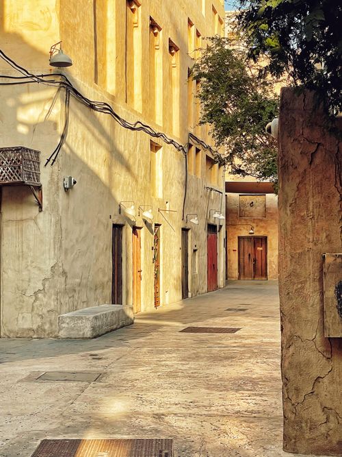 Free A serene sunlit alley with ancient architectural charm and golden walls. Stock Photo