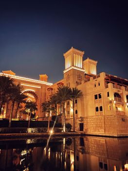 Stunning night view of a luxurious resort in Dubai with architectural elegance and palm trees.