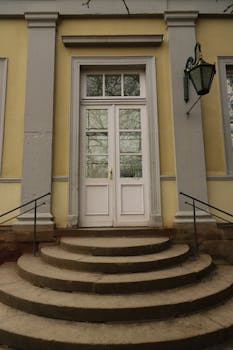 Grand entrance at Schloss Wilhelmshöhe in Kassel, Germany, featuring a vintage design with stone steps.