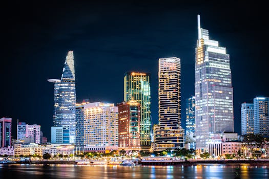 Stunning night view of Ho Chi Minh City's skyline with illuminated skyscrapers reflecting on the river.
