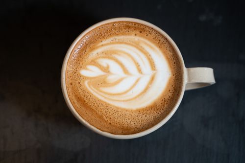 Free Top view of a cappuccino with latte art on a dark table in a Berlin café. Stock Photo