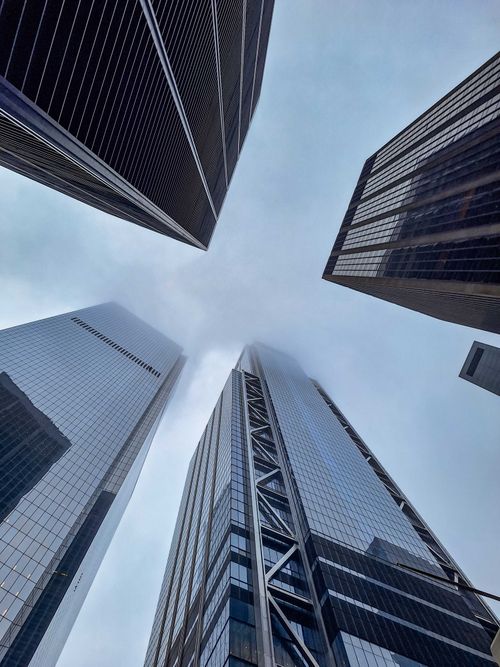 Free Modern skyscrapers reaching into the clouds with a dramatic perspective against a cloudy sky. Stock Photo