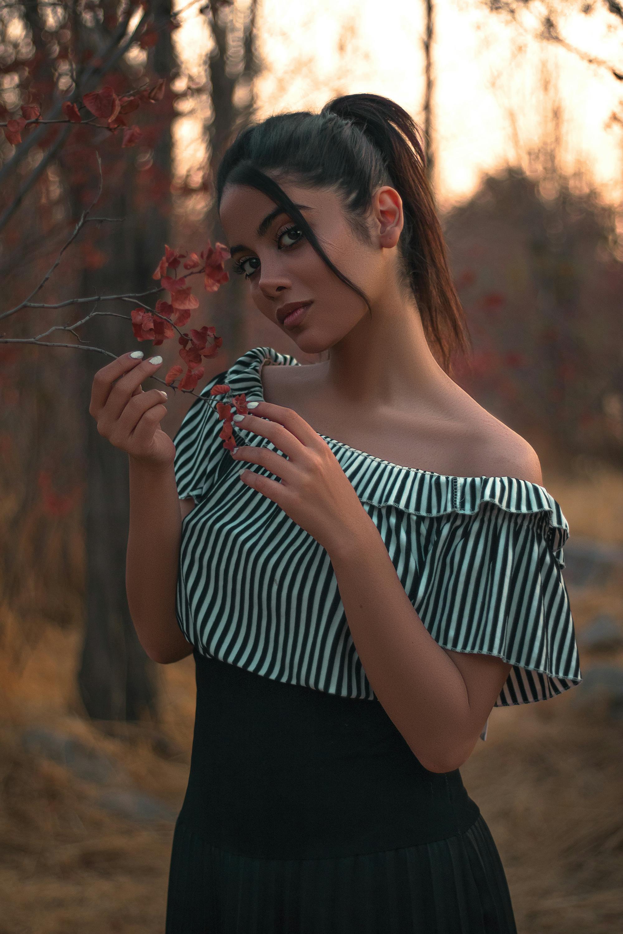 一位时尚女性在宁静的秋日森林中优雅摆姿，尽显风范