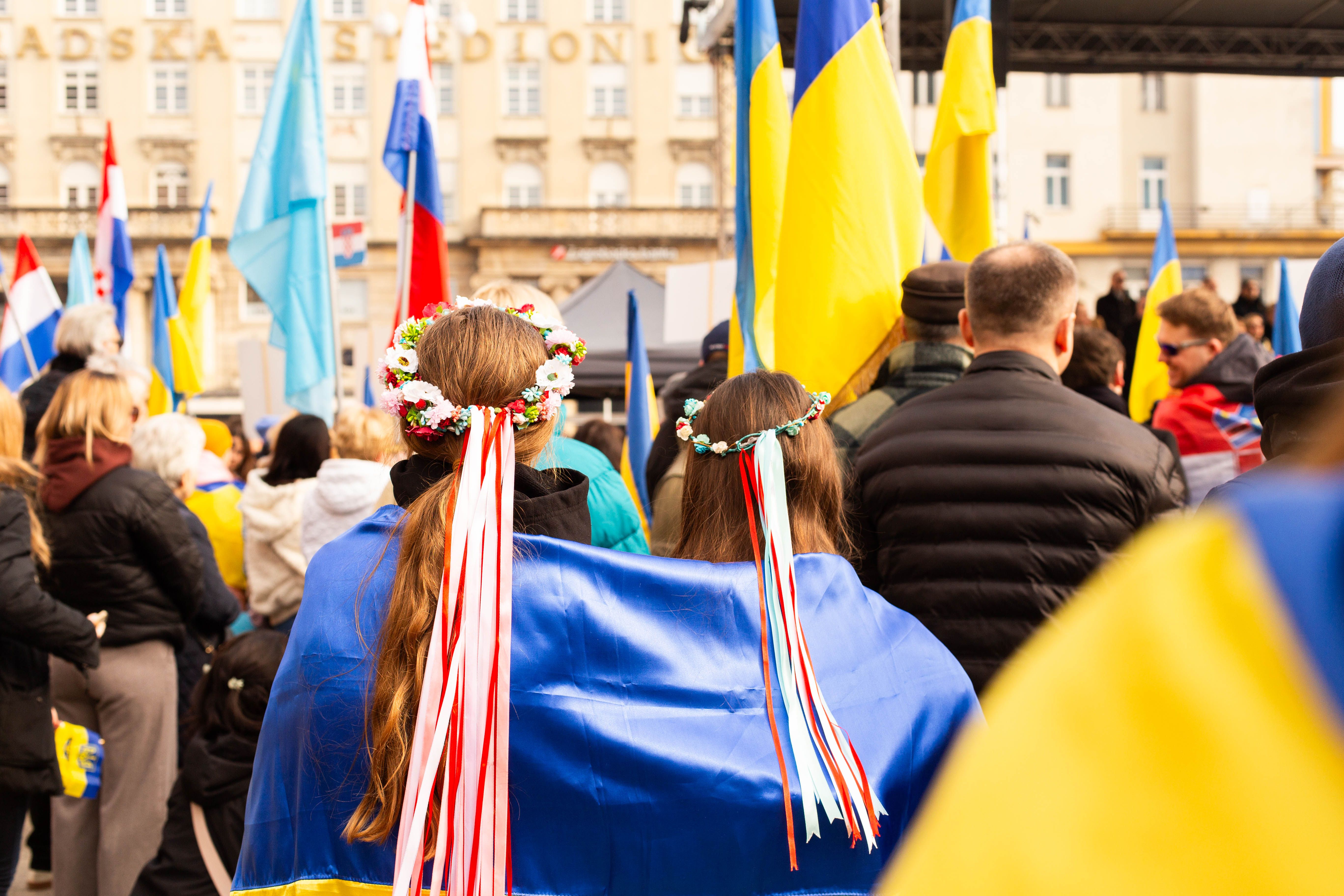 A peaceful rally in Zagreb featuring Ukrainian flags and cultural attire, promoting unity.